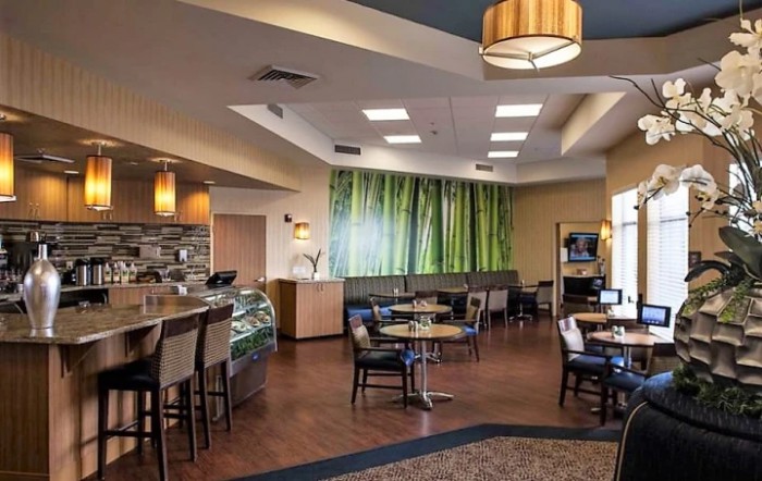 A modern cafe with a cozy seating area and decorative lighting.