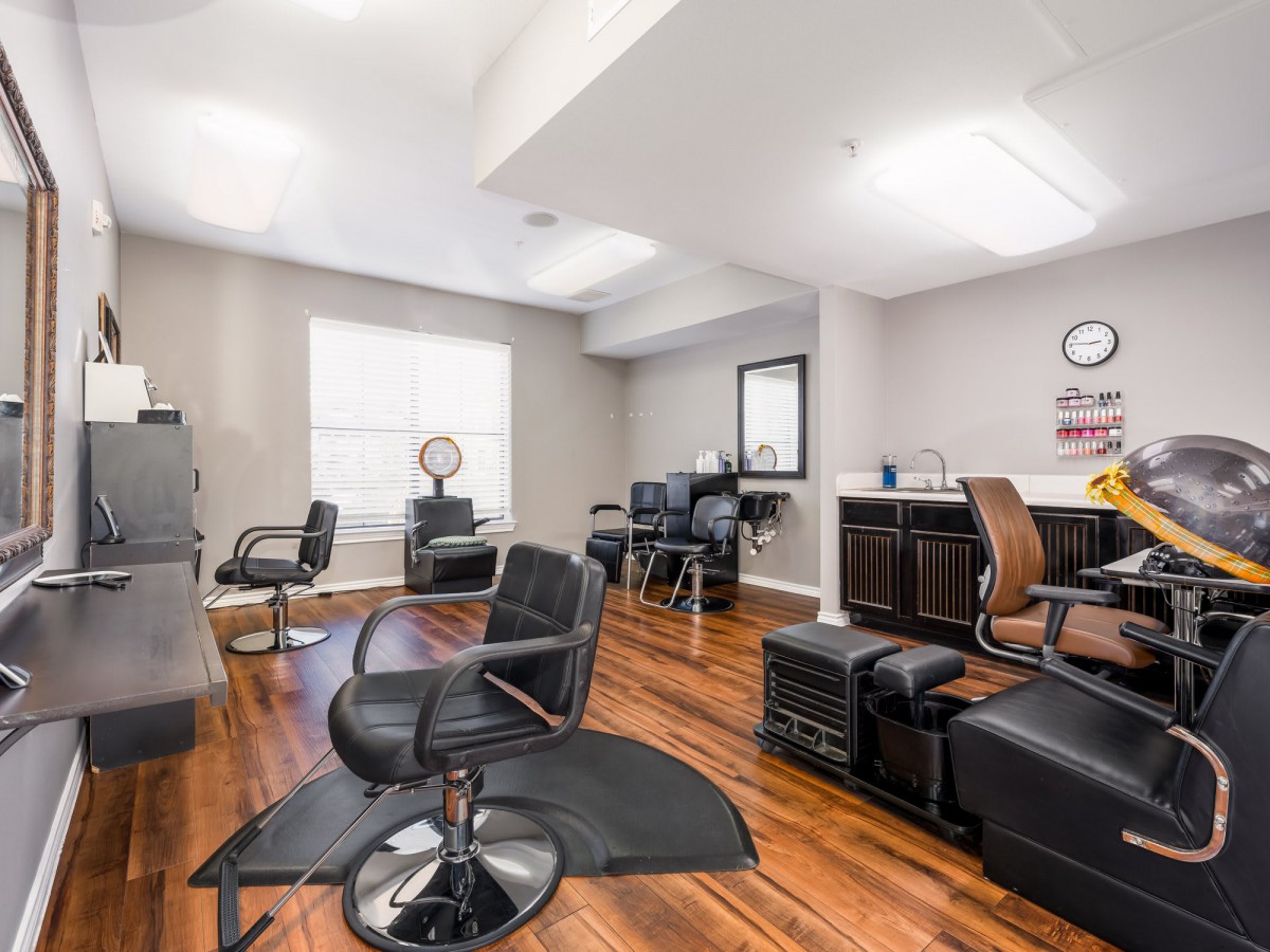 A modern hair salon interior with stylish chairs and mirrors.