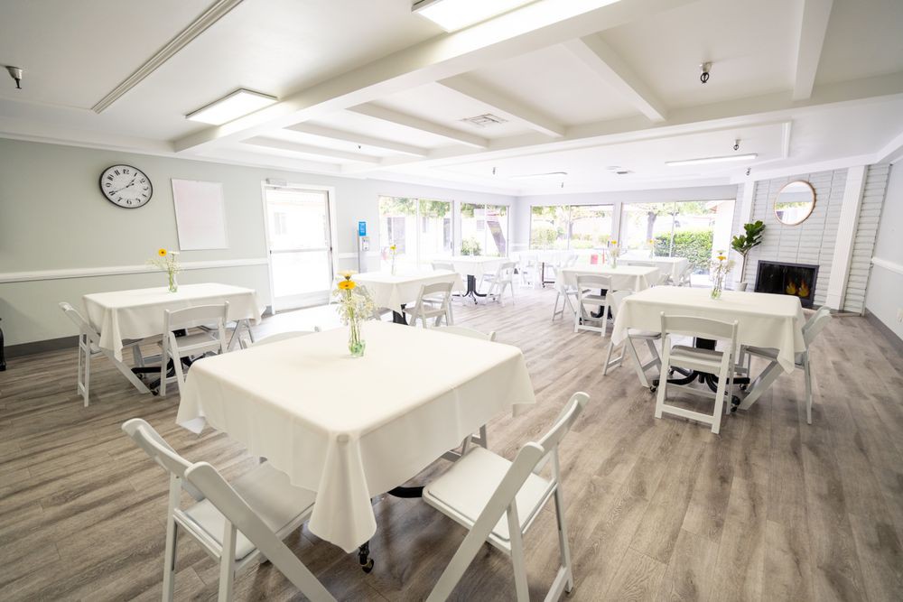 A bright and airy dining area with white tables and chairs.