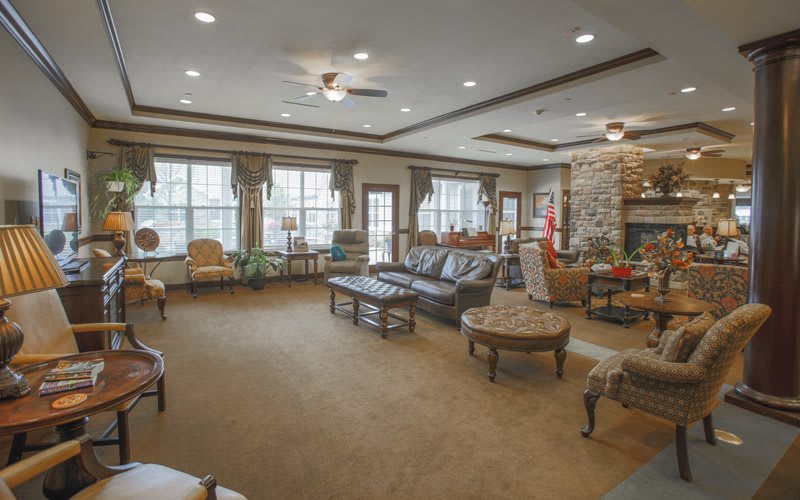 A spacious and elegantly furnished living room with a fireplace and large windows.