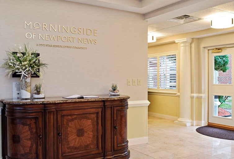A well-decorated office reception area with a wooden desk and wall decor.