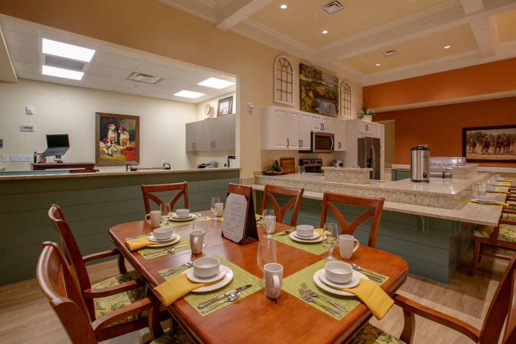 A modern dining room and kitchen area with a neatly set table.