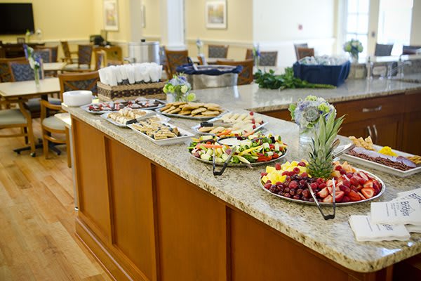 A buffet table with an assortment of food, including sandwiches, cookies, and fruit platters.