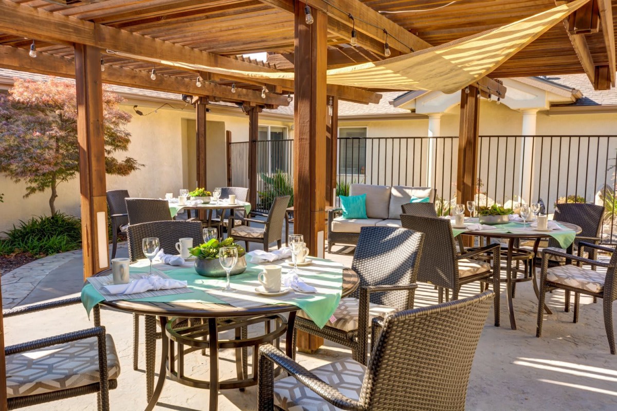 An inviting outdoor patio dining area with tables set under a pergola.