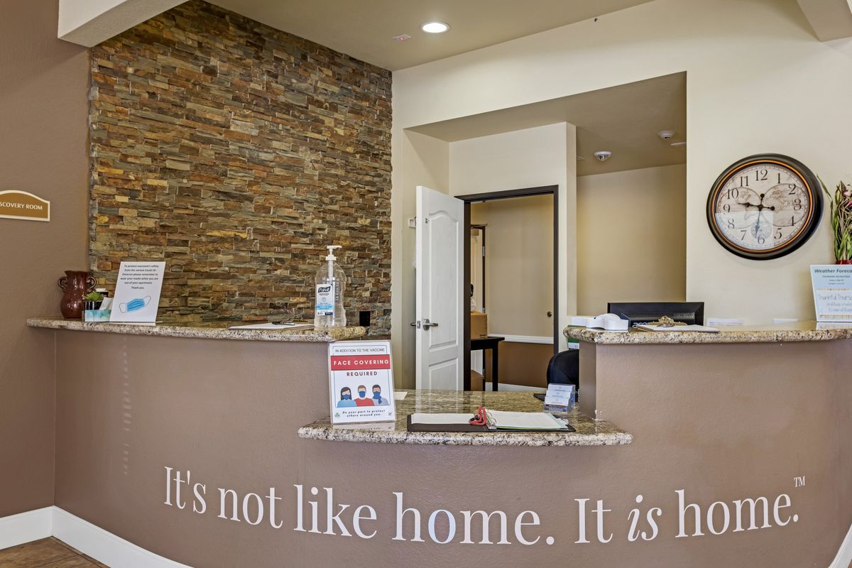 A welcoming reception area with a modern desk and quote on the front panel.