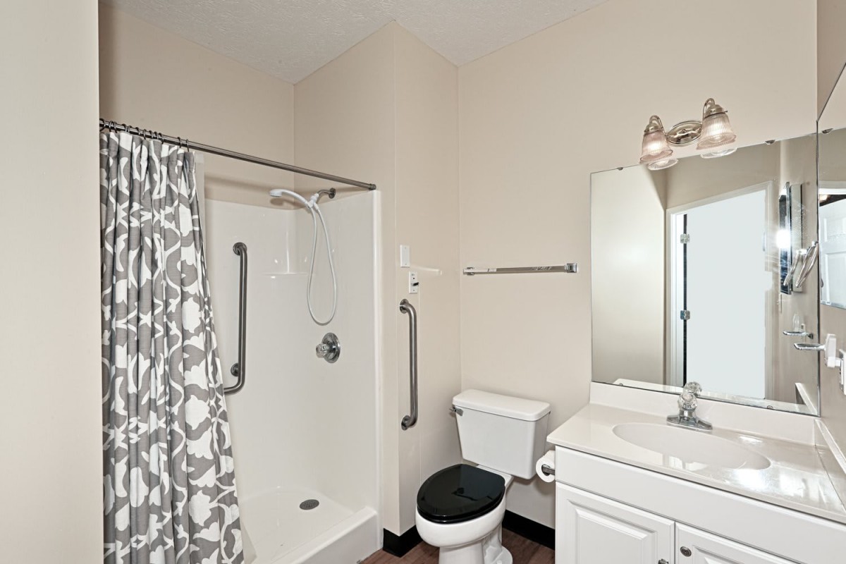 A simple bathroom with a shower, toilet, and vanity.