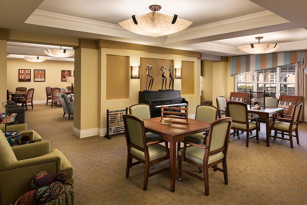A well-furnished living area with a table and chairs, ambient lighting, and decorative artwork on the walls.
