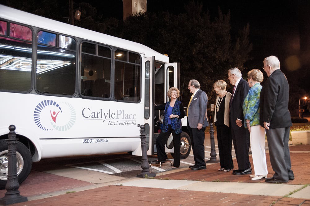 A group of people boarding a bus at night in an urban area.