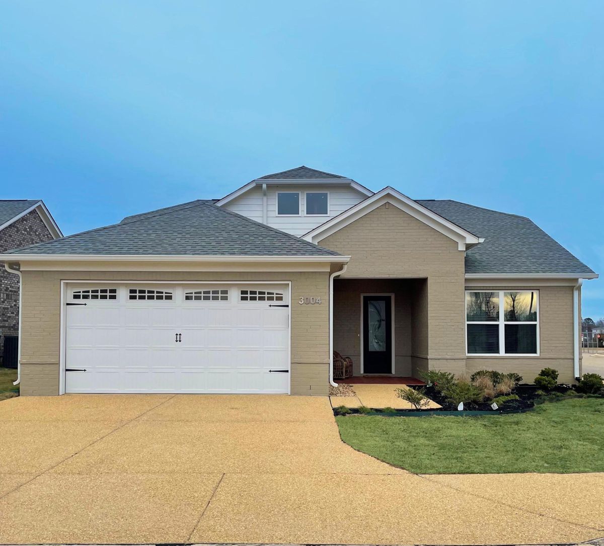 A suburban house with a two-car garage and well-maintained lawn.