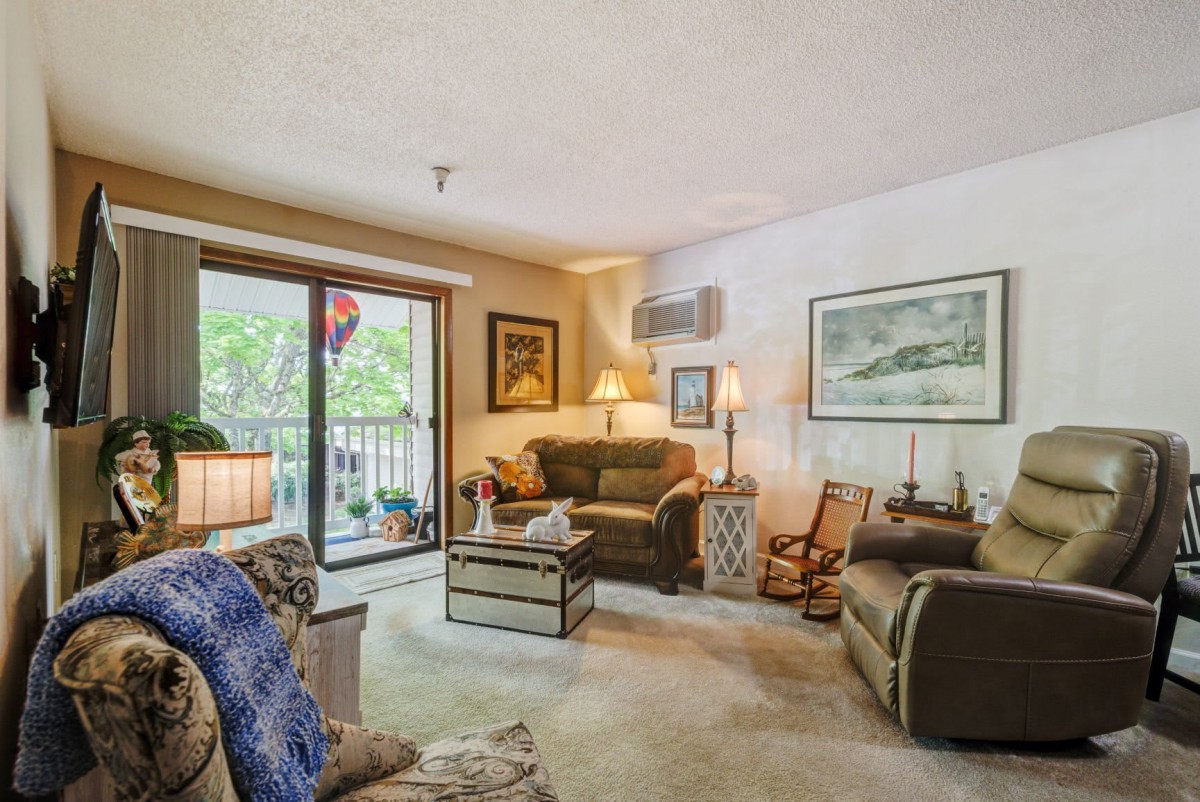 A cozy living room with comfortable seating and a view of the balcony.