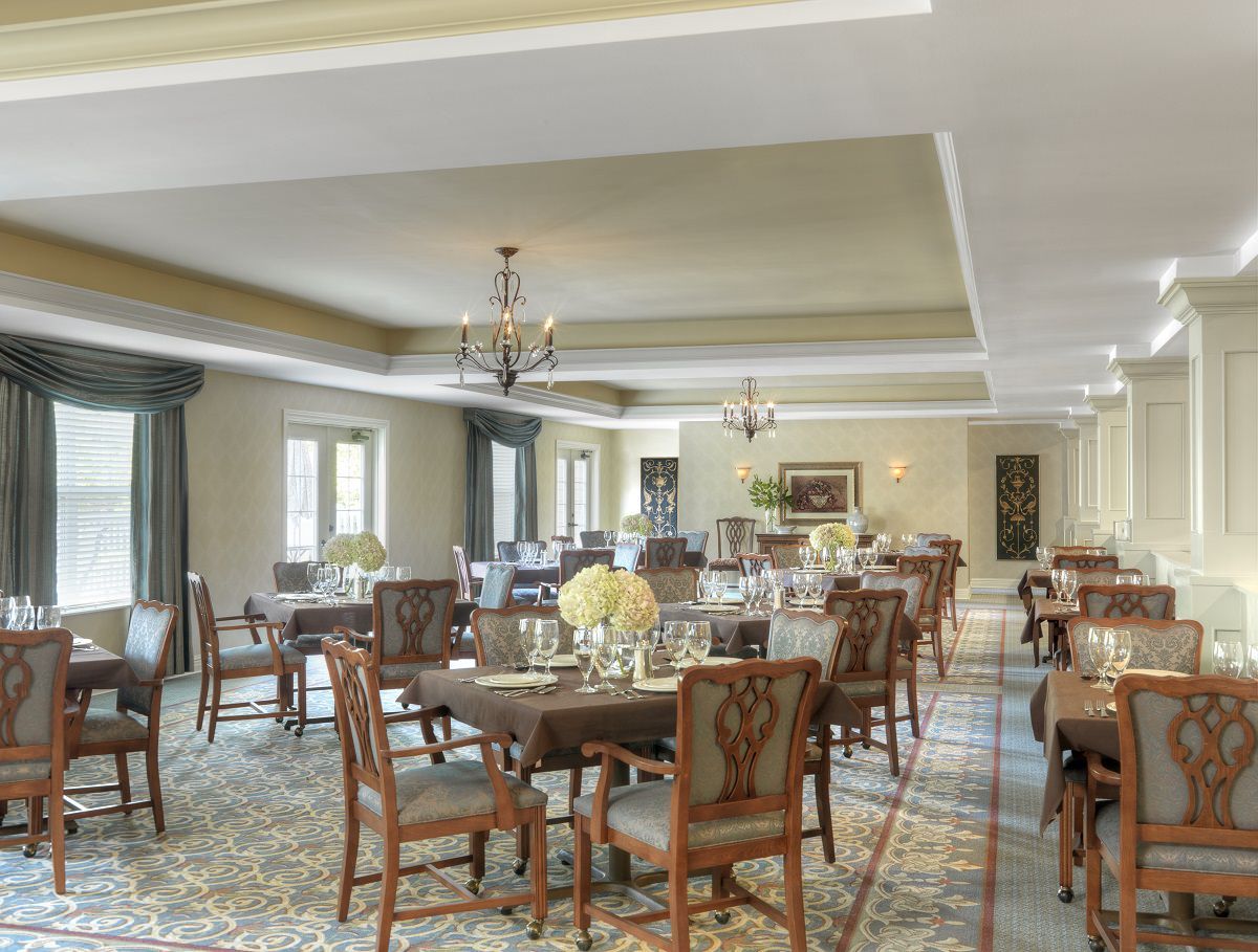 Elegant dining room with neatly arranged tables and classic chandeliers.