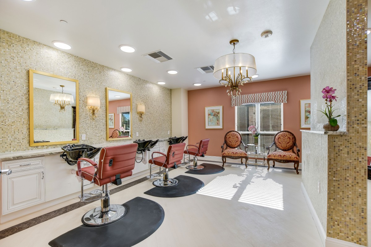 An elegant hair salon interior with stylish chairs and well-lit mirrors.