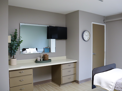 A modern hotel room featuring a simple design with essential furniture.