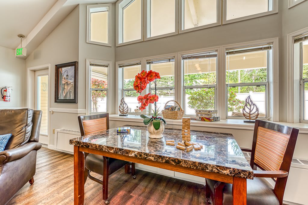 A well-lit dining area with a large table and decorative orchid centerpiece.