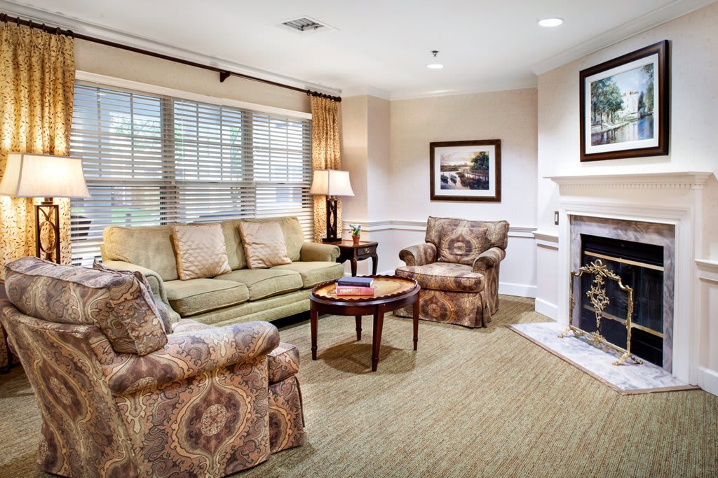 Cozy living room with a sofa, armchairs, and a fireplace.