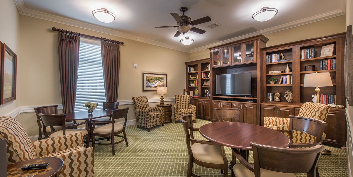 A cozy living room with comfortable seating, a TV, and bookshelves.