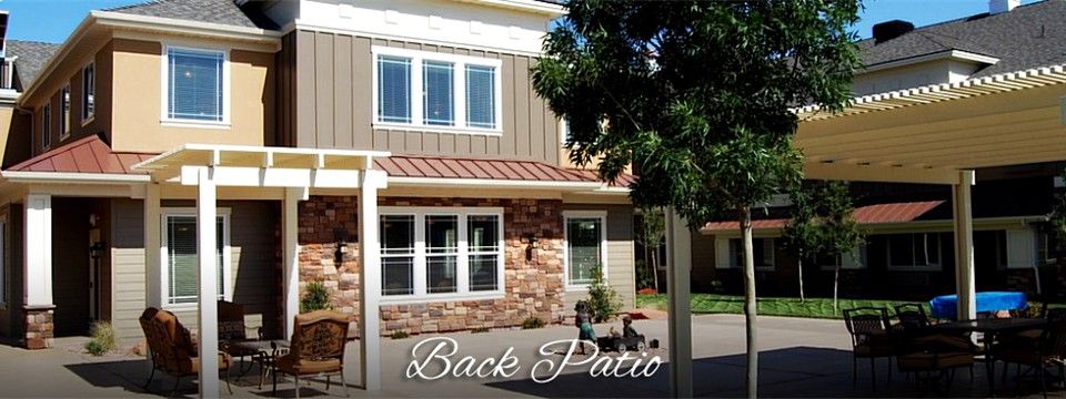 A cozy back patio area with a stylish house exterior, featuring stone and siding details.