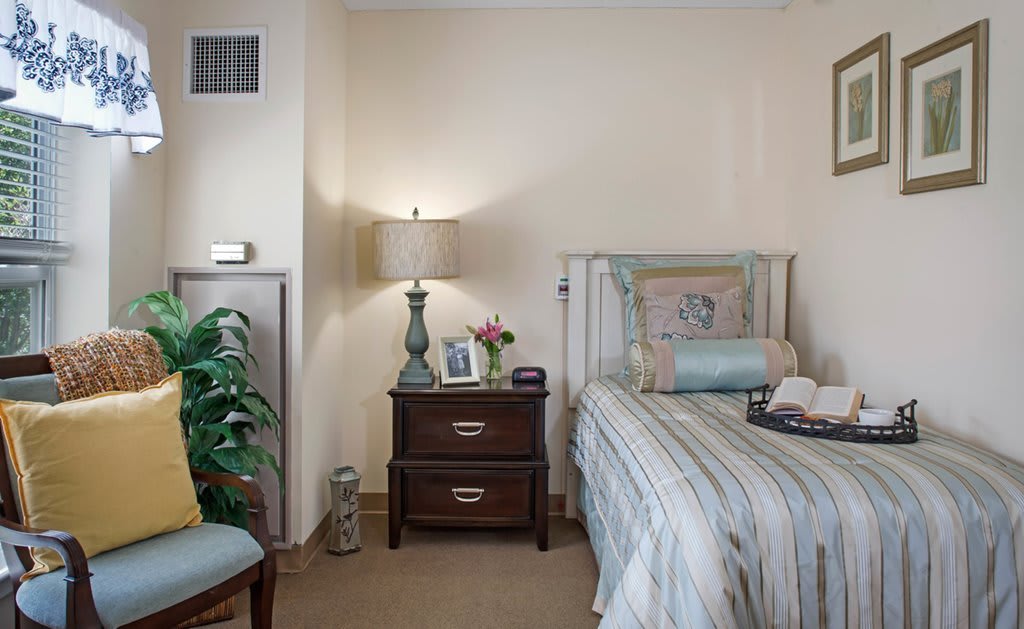 A cozy bedroom with a striped bedspread, nightstand, and decorative accents.
