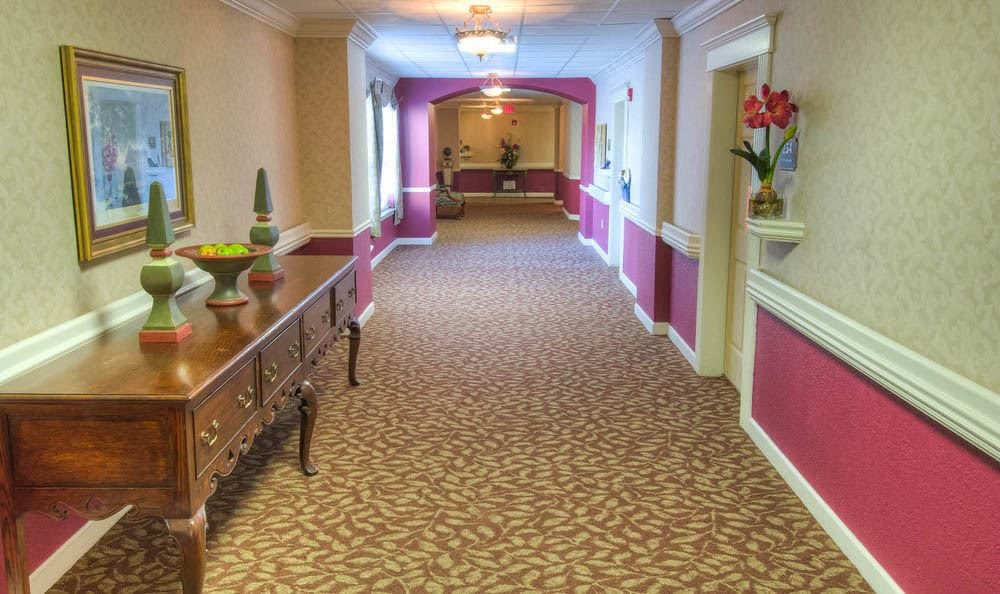 A warmly decorated hallway with patterned carpet and elegant furnishings.