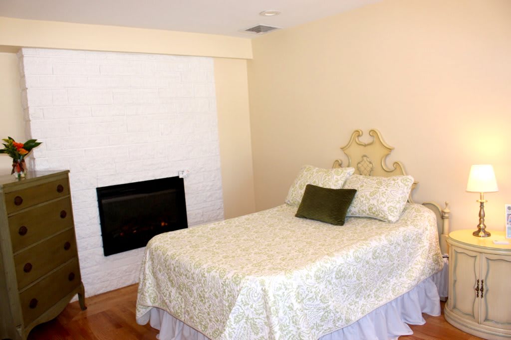 A cozy bedroom with a single bed and a fireplace.