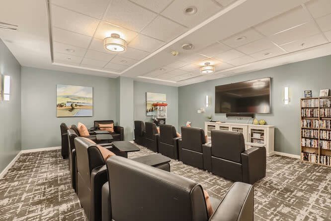 A modern home theater room with organized seating and a large screen.
