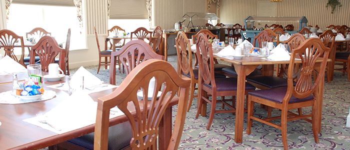 A cozy restaurant dining area with wooden chairs and tables.