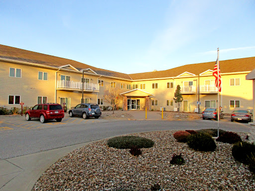 A view of a residential building with an accessible parking area and well-maintained landscaping.