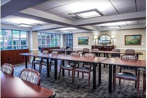 A well-lit conference room with neatly arranged tables and chairs.