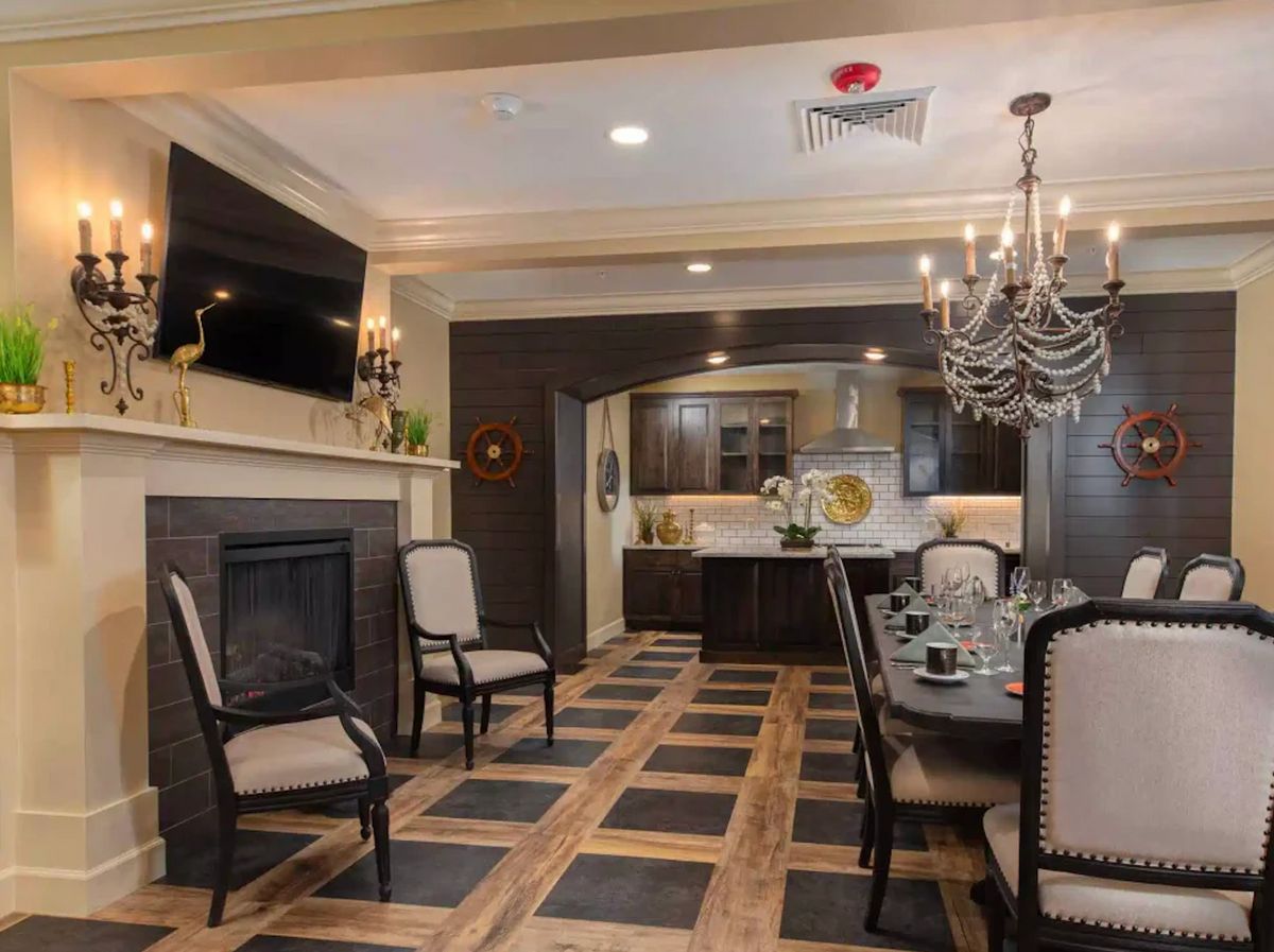 A stylish dining room featuring a chandelier, fireplace, and modern decor.