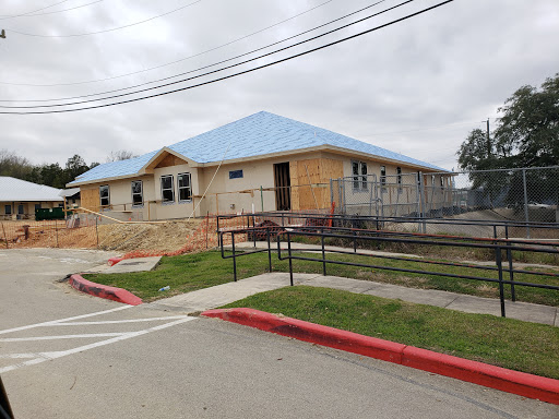 A newly constructed building with a blue roof, still under development.