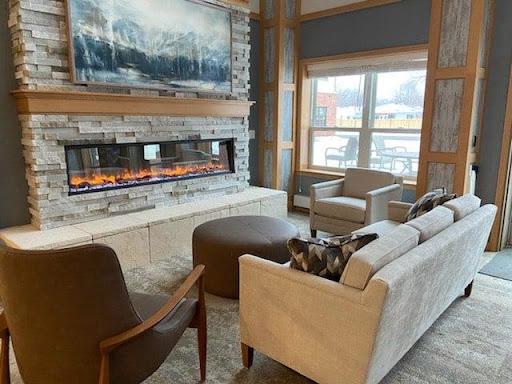 A beautifully designed living room featuring a modern fireplace, comfortable seating, and natural light.