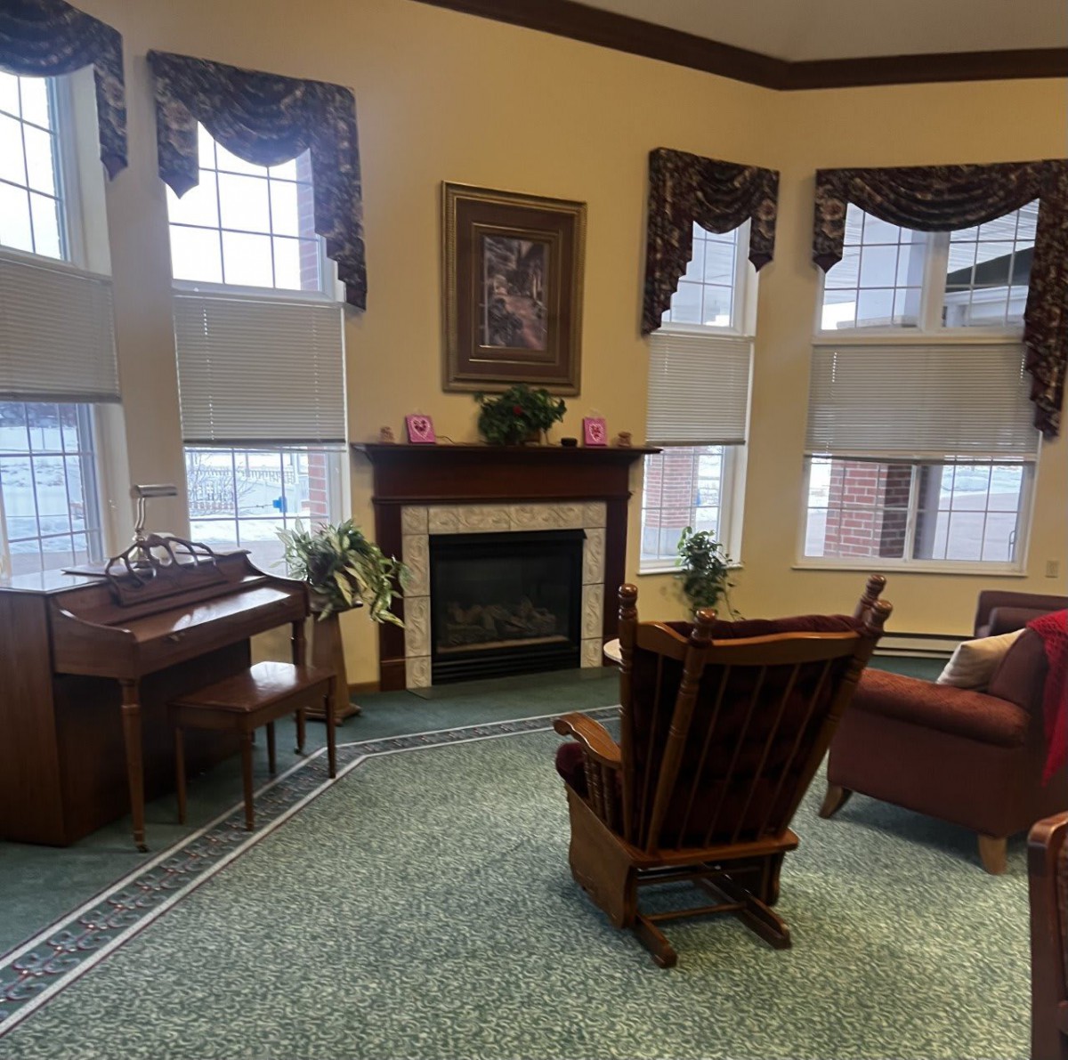 A cozy living room with a fireplace, piano, and comfortable seating.