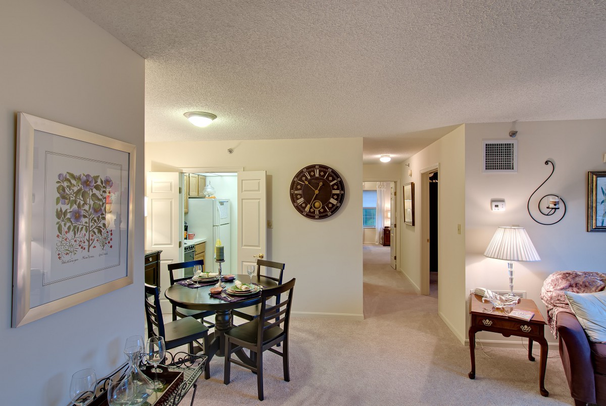 A cozy apartment interior featuring a dining table, kitchen, and living area.