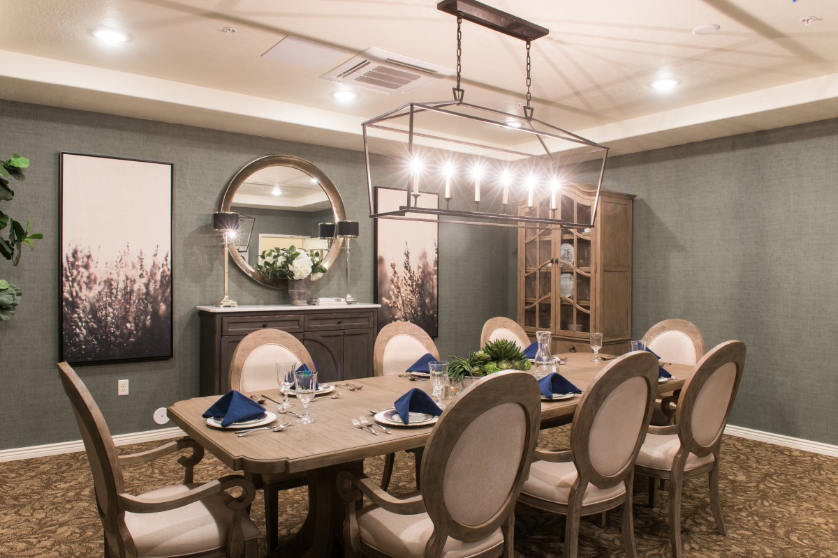 Elegant dining room with a chandelier and well-set table.