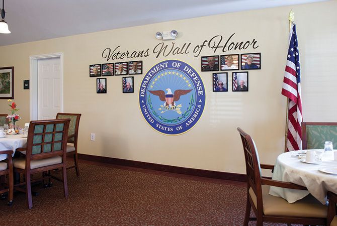A Veterans Wall of Honor featuring photographs and a prominent Department of Defense emblem, commemorating military service members.