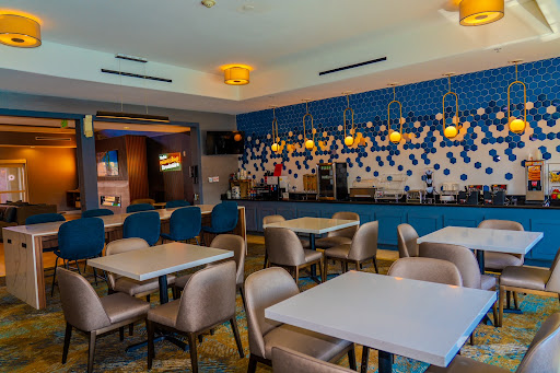 A stylish and modern restaurant interior featuring blue walls, cozy seating, and warm lighting.