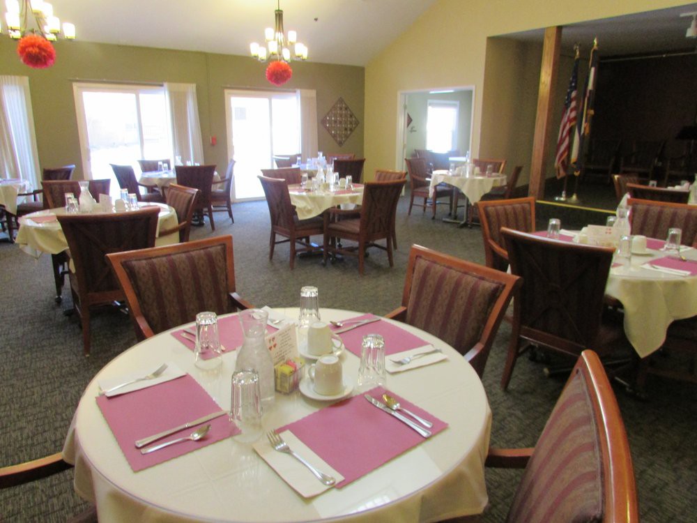 An empty dining room with neatly set tables and chairs, ready for guests.
