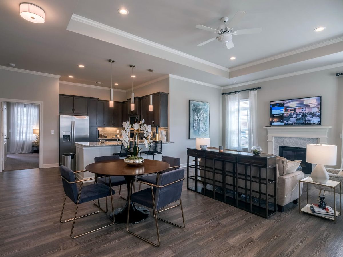 A modern open-floor-plan living area featuring a cozy dining space, contemporary kitchen, and elegant living room with stylish furnishings.