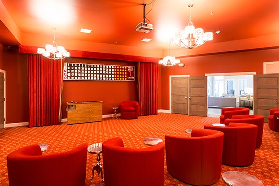 A vibrant red meeting room with circular seating and chandeliers.