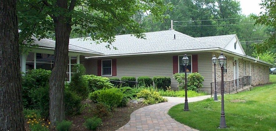 A suburban house with a landscaped garden and brick pathway.