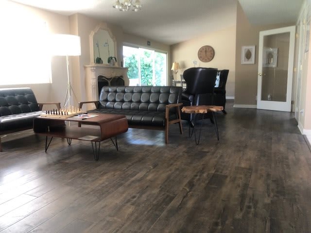 A modern living room featuring a sofa, armchairs, and a coffee table on a hardwood floor.