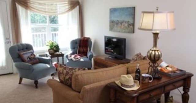 A cozy living room with comfortable seating, a TV, and tasteful decor.