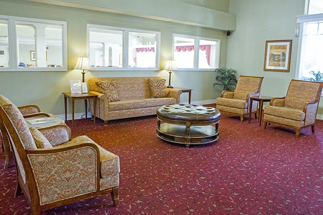 A cozy living room with classic furniture and a warm carpet.
