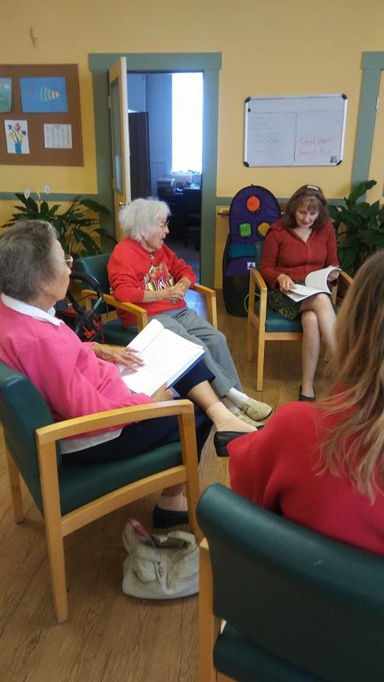 A group of elderly women enjoying a book club meeting.