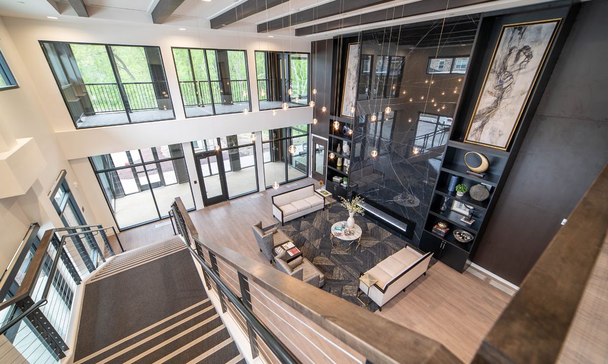 A spacious and modern open-plan living room with large windows and elegant furnishings.