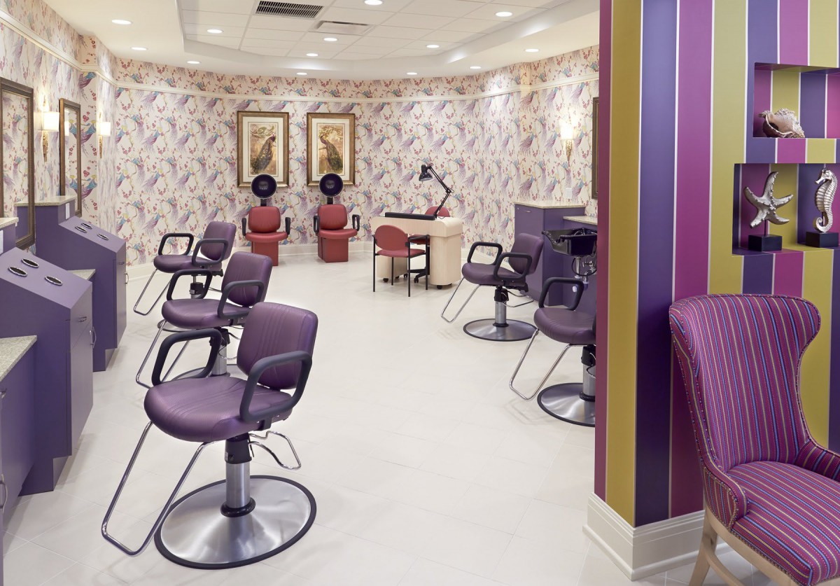 A modern hair salon interior with purple chairs and hair dryers.