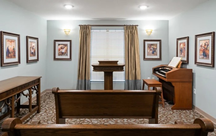 A small chapel interior with a pulpit, organ, and pews.