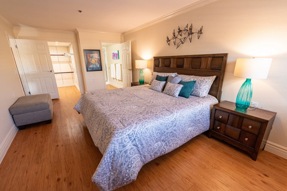 A cozy bedroom with a large bed, decorative pillows, and warm lighting.