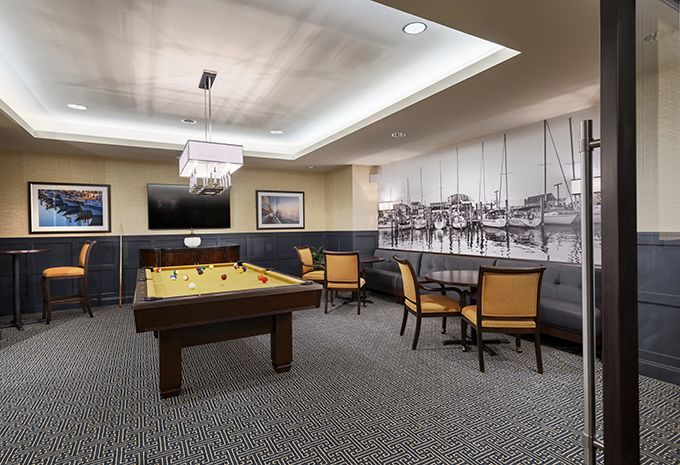 A modern game room featuring a billiards table and a cozy seating area.