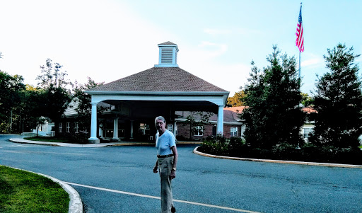 An elderly man walking towards a residential building.